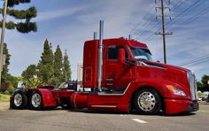 a red semi truck is parked on the side of the road