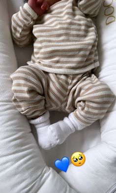 a baby laying on top of a white pillow