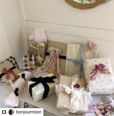 many wrapped presents are sitting on a bench in front of a mirror with a wreath