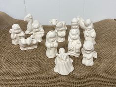 a group of white figurines sitting on top of a burloom cloth