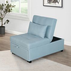 a light blue chaise lounger sitting on top of a rug in front of a window