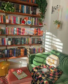 a green couch sitting in front of a book shelf filled with books