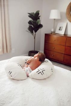 a baby laying on top of a white bed