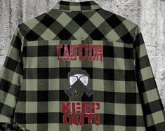 a black and white checkered shirt that says caution keep out