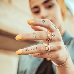 a woman with tattoos on her fingers making a hand gesture