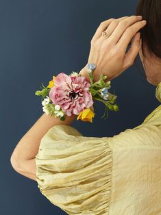 a woman wearing a yellow dress holding a bouquet of flowers