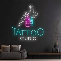 a living room with a couch, coffee table and neon tattoo studio sign