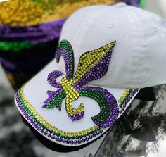 a mardi gras hat is adorned with beads and fleur de lis