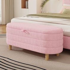 a pink footstool sitting on top of a bed next to a white rug