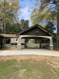 a covered picnic area in the middle of a park with benches and trees around it