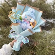 a person holding a bouquet of flowers in their hand with a stuffed animal on it