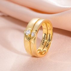 two gold wedding rings with diamond hearts on each side and the words, i love you to