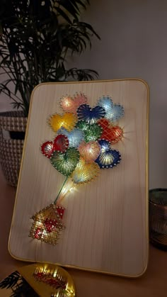 there are many decorative lights on the wooden board in front of some plants and other decorations