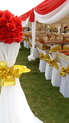 an outdoor wedding setup with red and white flowers