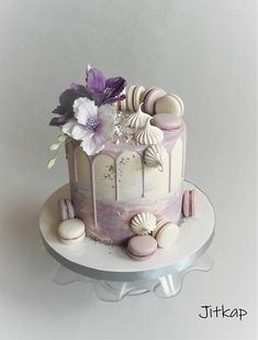 a white cake with purple icing and flowers on top