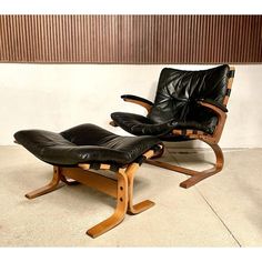 two black leather reclining chairs sitting next to each other in front of a wall