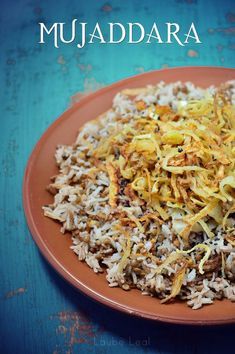 a plate full of rice and other food on a blue table with the words muaddara written above it