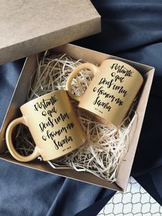 two coffee mugs in a gift box with writing on the inside and outside of them