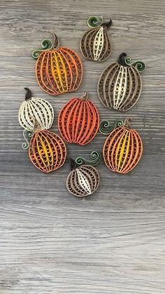 six decorative pumpkins on a wooden surface