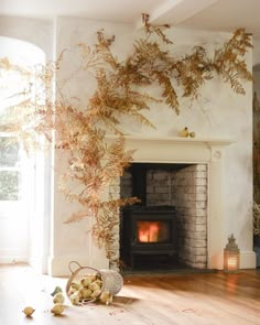 a fireplace in a living room next to a basket filled with apples and lemons