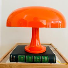 an orange table lamp sitting on top of a book