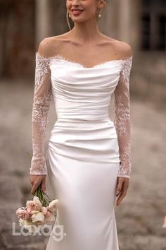 a woman in a white wedding dress holding flowers