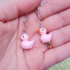 a pair of pink rubber ducks dangling from chain earrings