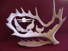 a white deer antler with two birds on it