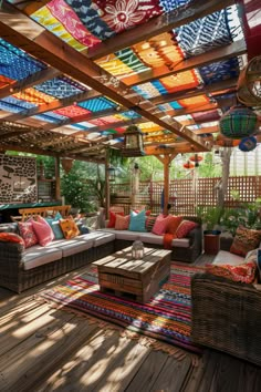 an outdoor living room with lots of colorful pillows on the couches and rugs