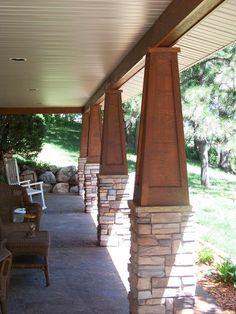 an outdoor covered porch with chairs and tables