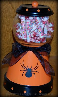 an orange candy dispenser filled with halloween candies and spider webs