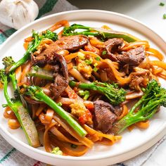 a white plate topped with pasta and veggies