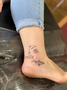 a woman's foot with a dolphin tattoo on it