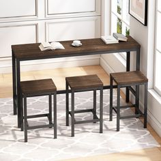 three stools and a table in front of a window with a book on it