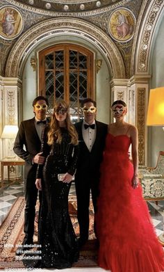 three people in formal wear standing next to each other with masks on their faces and one woman wearing a red dress