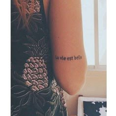 a woman with a tattoo on her arm that says la vie est belle in french