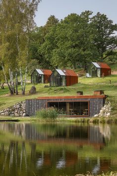 several small houses on the side of a lake