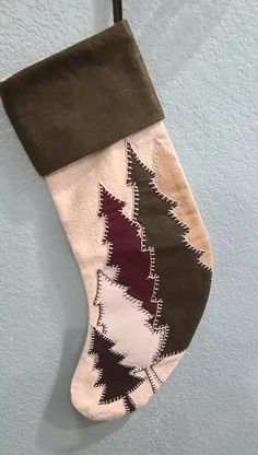 a christmas stocking hanging from a hook on the wall with an ornament