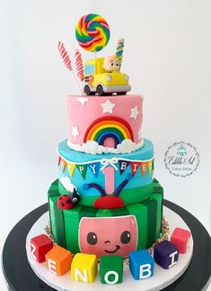 a multi layer cake decorated with toys and letters