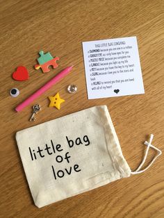 a little bag of love is sitting on the table next to some magnets and other items