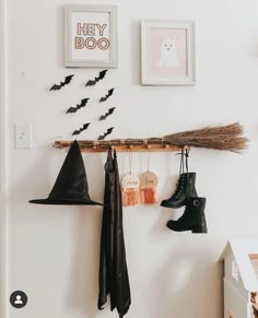 there is a coat rack with hats, boots and bats hanging from it's hooks