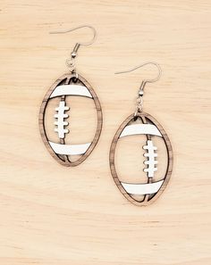 "These lightweight wooden football earrings are laser cut from lightweight, 1/8\" walnut wood. The stitches and stripes are handpainted white the earrings hang from stainless steel earring hooks.  The drop length (including the ear wire) is 2.25\". The football itself is 1.5\" tall by 1\" wide. Visit my Etsy shop (PurpleDaisyRoom) for other available sports: baseball, softball, basketball, volleyball and soccer." Plunder Football Earrings, Wooden Football, Football Earrings, Football Lover, Football Lovers, Football Gifts, Football Mom, Baseball Softball, Sports Baseball