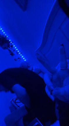 a person laying on the floor in a room with blue lights and remotes next to them