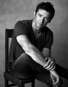 a black and white photo of a man sitting on a chair