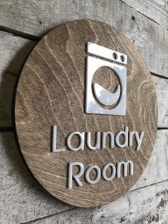 a wooden sign that says laundry room with a washing machine on it's side