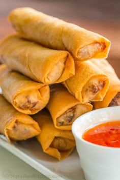 some food on a white plate with dipping sauce