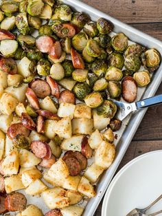 a pan filled with potatoes, brussel sprouts and sausage