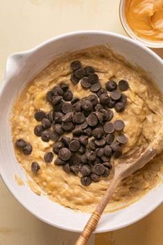 a bowl filled with oatmeal and chocolate chips next to a wooden spoon