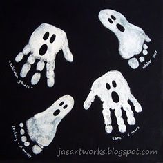 four white hand prints on black paper