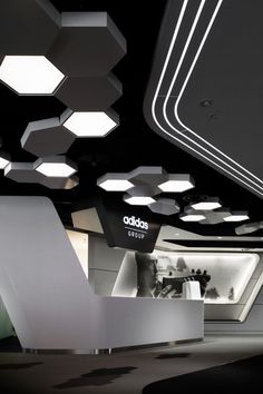 the interior of an office building with lights hanging from the ceiling and hexagonal shapes